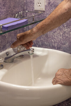 Bathroom sink man's hand turning on water