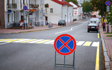 No parking, road sign is in front of pedestrian crossing. No parking and stopping on the road -...