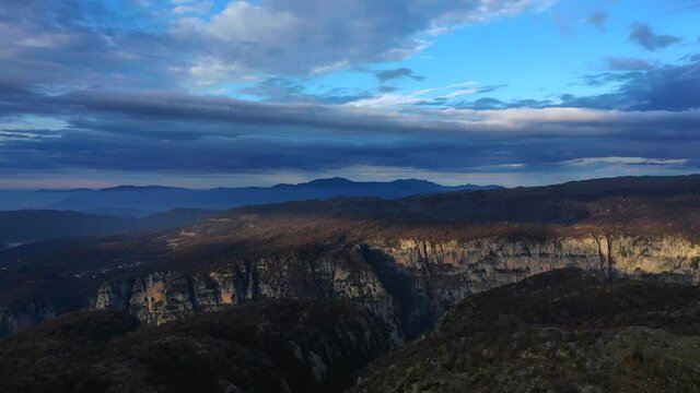 Couple standing on the top of mountain rocks on Vikos Gorge, aerial photo by drone