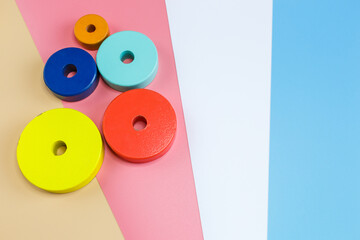 Wooden toys, blocks on pink blue white orange background. Close up. Top view, copy space. Educational games for kindergarten, preschool kids