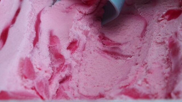 Slow motion Closeup scooping Ice cream Strawberry out from container with a spoon, Closeup top view Food concept.