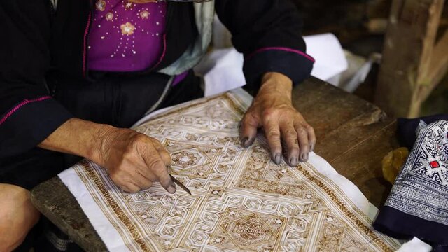 mujer anciana pintando sobre telas