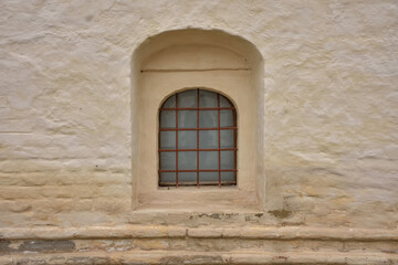 Fototapeta na wymiar window with bars in fortress wall, loophole with bars