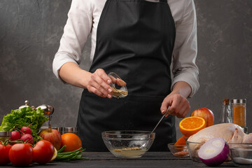 Cooking garlic sauce for preparing a festive chicken, turkey or duck, against a background of vegetables and fruits. Freezing in motion. Cooking and gastronomy. Christmas dinner or Thanksgiving.