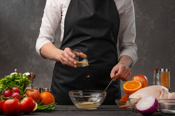Cooking, the chef prepares garlic sauce sprinkling seasoning, freezing in motion. Cooking and recipes. Against the background of vegetables. Restaurant business