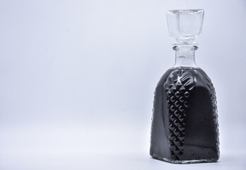 carafe with black liquid on a white background