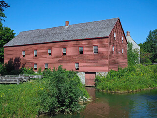 Fototapeta na wymiar old wooden barn type building in a field beside a pond
