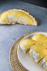 Close up durian the king of fruit in Thailand on white plate.Summer tropical Thai traditional fruits so delicious,spiky peel,sweet and good smell. Ripe durian has been peel yellow gold color.