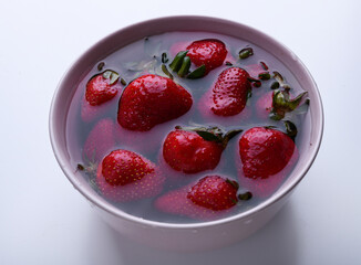 Fresh strawberries in a bowl with water