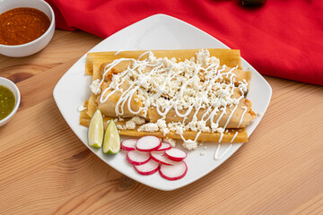 Handmade tamales filled with chicken and topped with sour cream and cotija cheese. A staple food in...