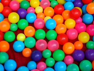 Fototapeta na wymiar colorful balls on red fabric background, children playground, joyful concept