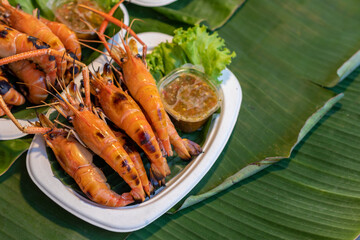 Grilled shrimp in a plate, placed on a banana leaf.