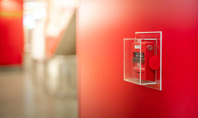 The red fire alarm switch on the red wall at the Bangkok subway.