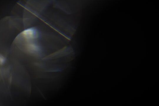 Dark wallpaper with bokeh light leaks against a black background for overlays