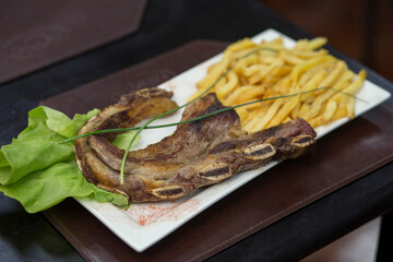 Carne vacuna, asado de tira con guarnición de papas fritas