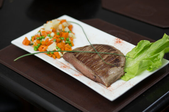 Filete de carne asada con ensalada de zanahoria, papas y arbejas