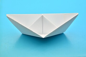 Barco de papel blanco aislado sobre fondo azul