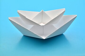 Barco de papel pequeño subido en otro más grande