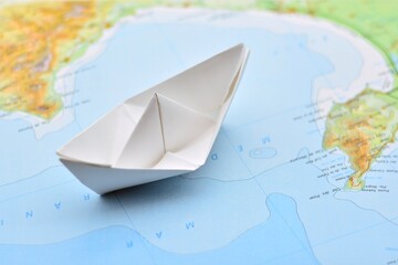 Barco de papel sobre un mapa difuminado