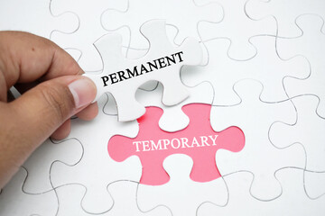 Missing puzzle with a word PERMANENT TEMPORARY. Business concept puzzle piece. Business and finance concept.