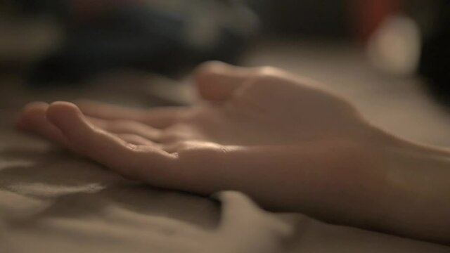 couple in bed holding hands slow motion