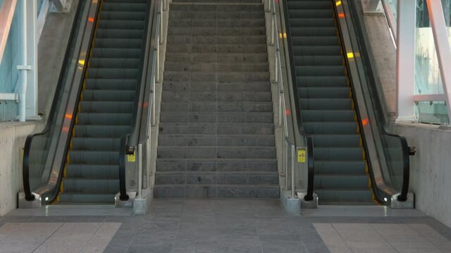 Two Empty Escalators Waiting For Commuters To Show Up.  One Going Up And One Going Down.