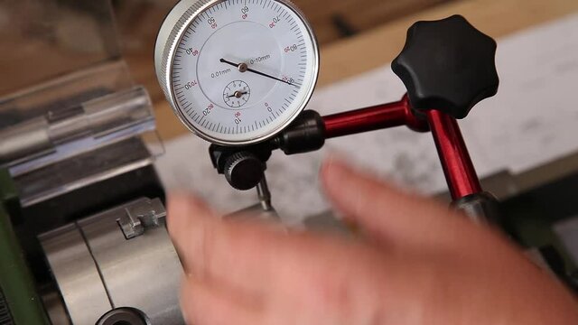 man using micrometer clock precision dial test indicator gauge scale