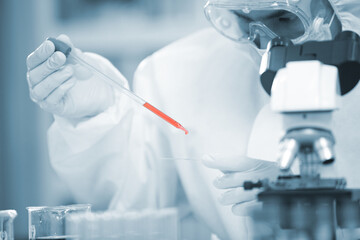 Doctor analyze corona or covid-19 blooding tube, he is finding the sample vaccine in laboratory and he is  wearing ppe suit and mask for protect the virus ,  medical mask, hospital