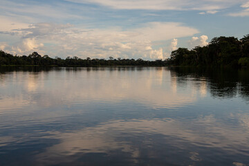 Dark Blue Cloudy Sky at Sunset Reflecting on the Lake in the Rain Forest Jungle