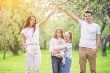 Fototapeta premium Adorable family in blooming cherry garden on beautiful spring day