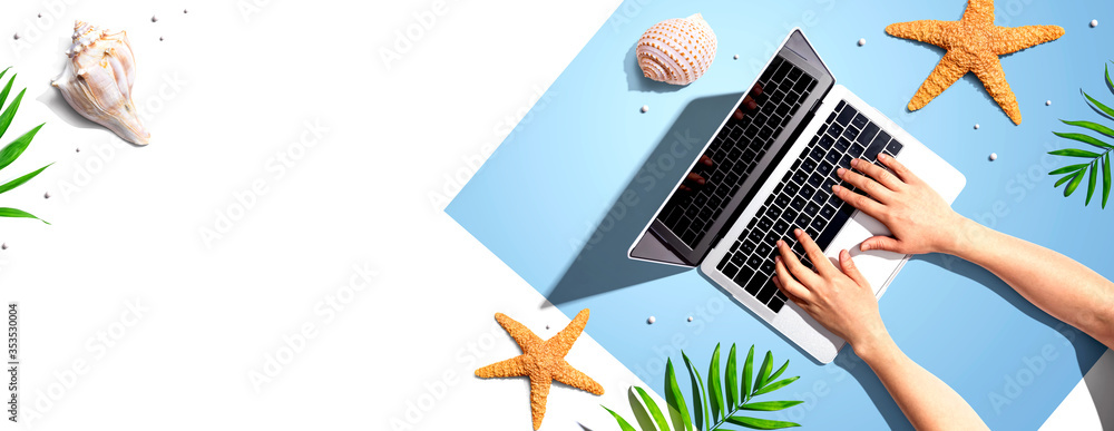 Poster person using a laptop computer with summer theme objects - flat lay