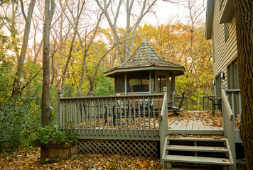 Gazebo made of wood in my backyard in the middle of a forest with leaves everywhere