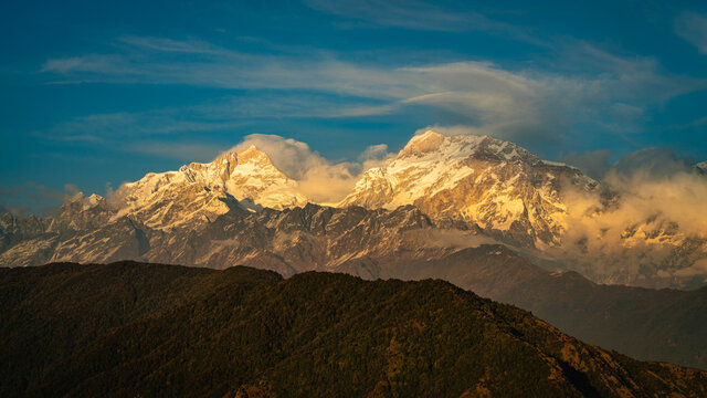 Lamjung Himal in Annapurna mountain range, visible from Ghalegaun, Lamjung in Nepal glowing wit hgolden warm light during sunset. 
