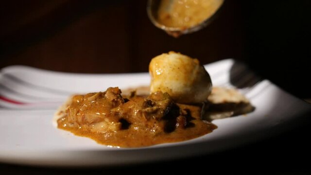 Closeup dolly out dramatic slow motion shot of parotta and chicken curry on a plate with a boiled egg  being served slowly coming into focus