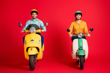 Portrait of his he her she nice attractive funny cheerful cheery confident couple riding moped traveling having fun isolated over bright vivid shine vibrant red color background