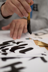 hand writing japanese calligraphy on a paper