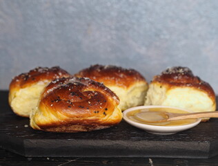 Homemade cake.The view on top of buns ,sprinkle with sesame seeds and sugar syrup on the dark table.