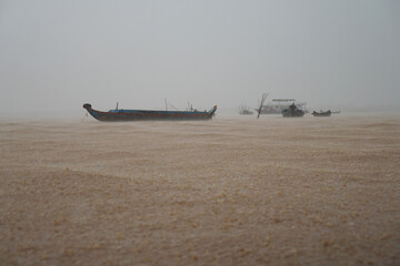 Obraz premium Tonle Sap Lake, Cambodia, fish boats on the waves during a storm, empty ships in the rain, cloudy haze, landscape without people 