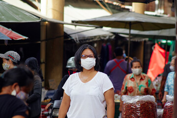 woman in masks for protection against viruses and flu on busy market streets