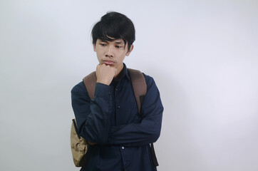 Young man a sad expression. Young Asian men wearing blue shirts and carrying bags isolated on a white background