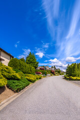 A perfect neighborhood. Houses in suburb at Summer in the north America. Fragment of a luxury house with nice window over blue sky.