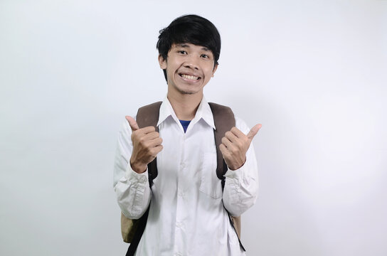 Young Asian men wearing white shirts and carrying bags isolated on a white background. Men are cheerful and show thumbs up
