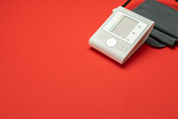 Blood pressure monitoring. Medical test monitor for blood pressure isolated on red background. Heart hypertension check with sphygmomanometer for doctor, patient. Hospital diagnostic technology.