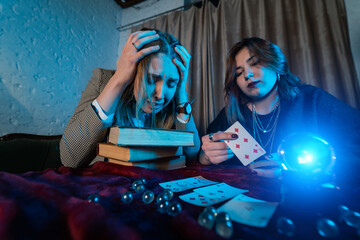 Fortune teller forecasting the future to woman with cards