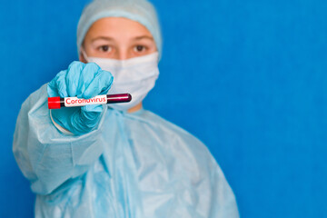 Blood test. A young medical worker holds a blood tube with the inscription coronavirus