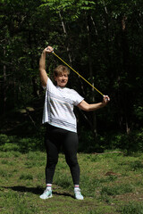 Senior woman doing sport and physical exercises outdoor. 