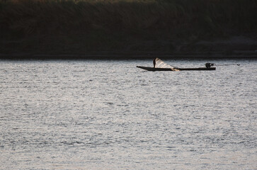  silhouette fisherman boat on mekong river