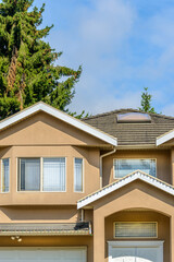 A perfect neighborhood. Houses in suburb at Summer in the north America. Top of a luxury house with nice window over blue sky.
