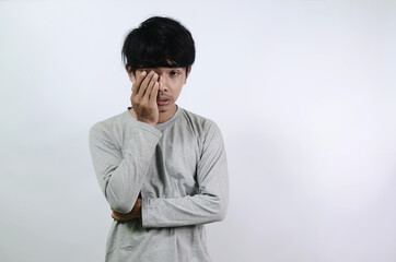 Asian men wearing gray long sleeve tshirts. A young man who looks sad and confused
