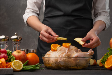 Decoration of a festive chicken by a chef with apples. Family dinner, homemade recipe for the hostess. Restaurant business and menu